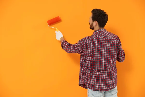 Designer Painting Orange Wall Roller Back View Space Text — Stock Photo, Image