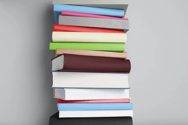 Stack of different books on light gray background