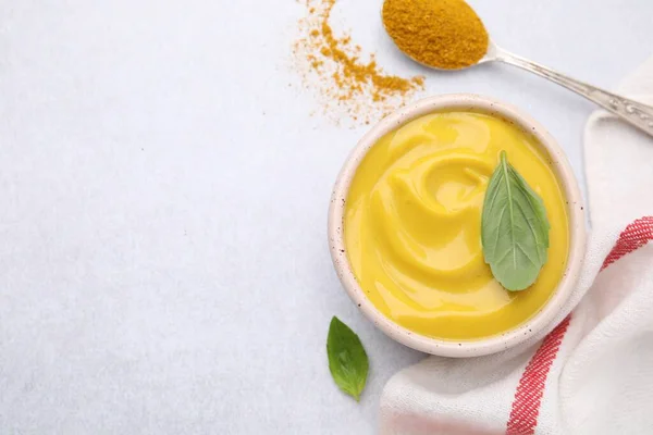 stock image Tasty curry sauce, powder and basil leaves on light table, flat lay. Space for text