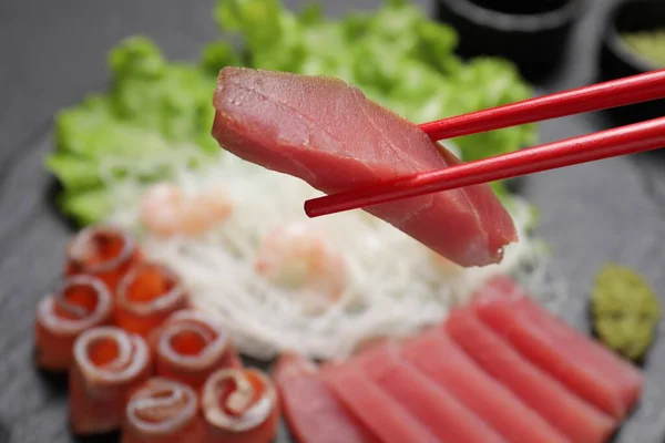 Chopsticks Com Sashimi Saboroso Pedaço Atum Cru Fresco Contra Fundo — Fotografia de Stock
