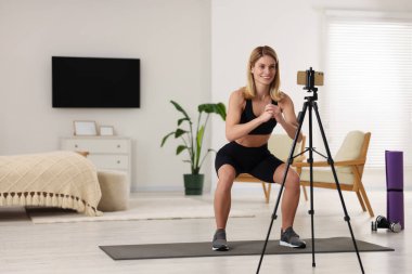 Fitness trainer recording online classes at home