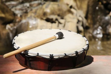 Güneşli bir günde göl kenarında davul sesi, yakın çekim. Perküsyon müzik aleti