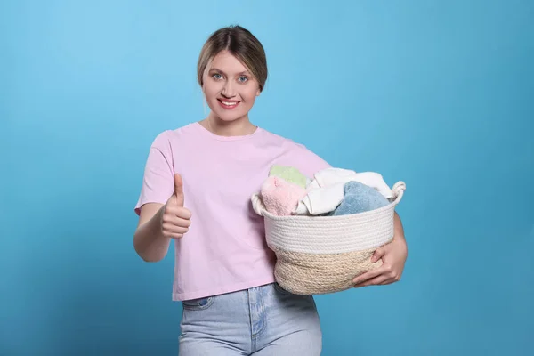 Happy Woman Basket Full Laundry Showing Thumb Light Blue Background — Stock Photo, Image