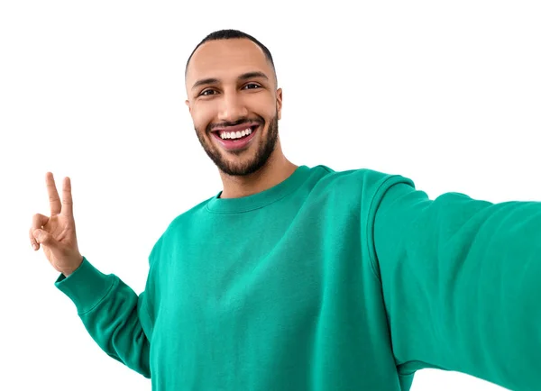 Uśmiechnięty Młody Człowiek Robi Selfie Pokazuje Znak Pokoju Białym Tle — Zdjęcie stockowe
