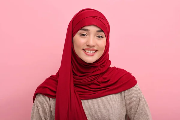 Portrait of Muslim woman in hijab on pink background