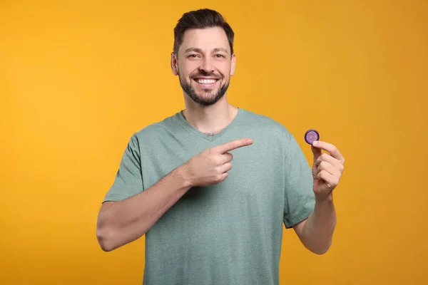 Happy Man Holding Condom Orange Background — Stock Photo, Image