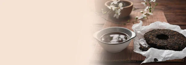 Aromatic pu-erh tea on wooden table. Banner design with space for text