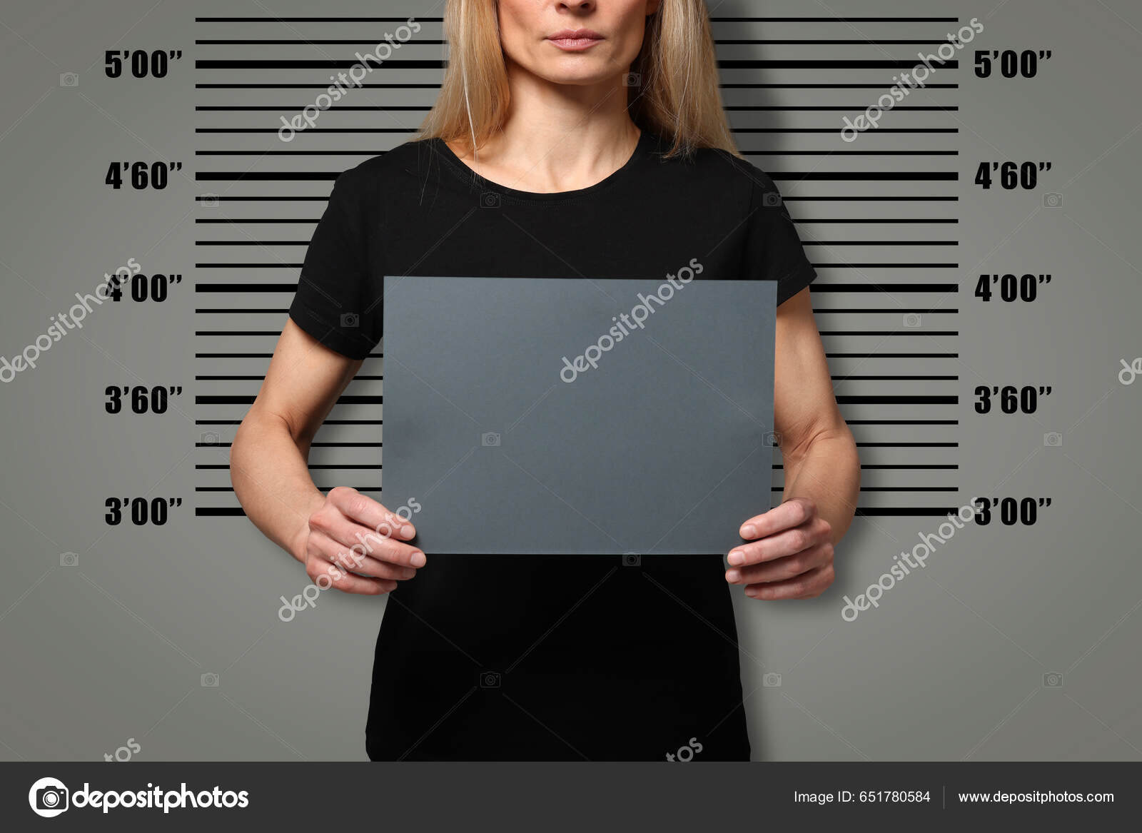 犯罪抢劫案持空白卡的被捕女性对照身高图表特写镜头——图库图片© NewAfrica #651780584