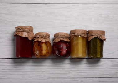 Konserve meyve reçelli kavanozlar beyaz ahşap masa, düz yatıyordu