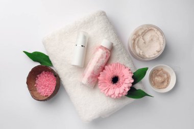 Farklı spa ürünleri ve beyaz masa üzerinde güzel bir çiçek içeren düz bir kompozisyon.