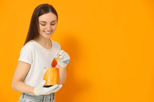Szczęśliwy Projektant Pędzlem Biorąc Farbę Puszki Pobliżu Pomarańczowej Ściany Miejsce — Zdjęcie stockowe