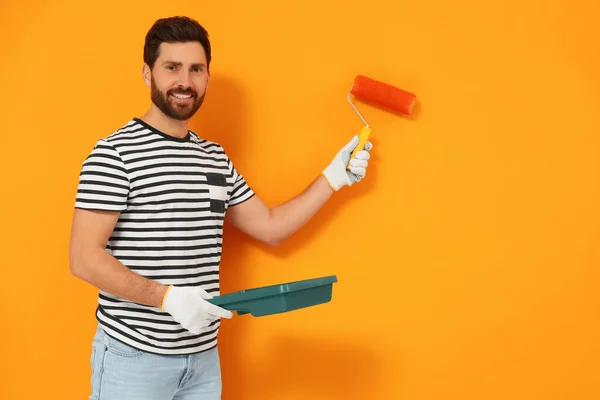 Diseñador Pintando Pared Naranja Con Rodillo Espacio Para Texto — Foto de Stock