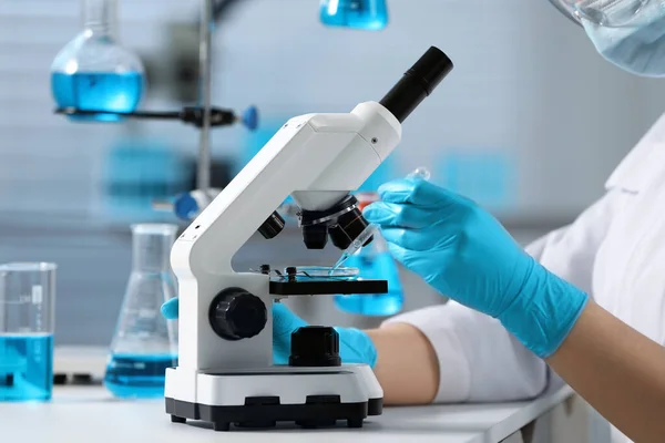 Naukowiec Kapiący Próbkę Płytkę Petriego Podczas Pracy Mikroskopem Laboratorium Zbliżenie — Zdjęcie stockowe