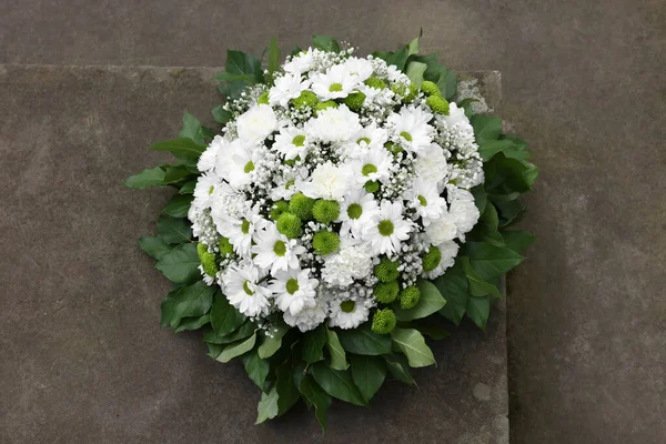 Funeral wreath of flowers on tombstone, above view