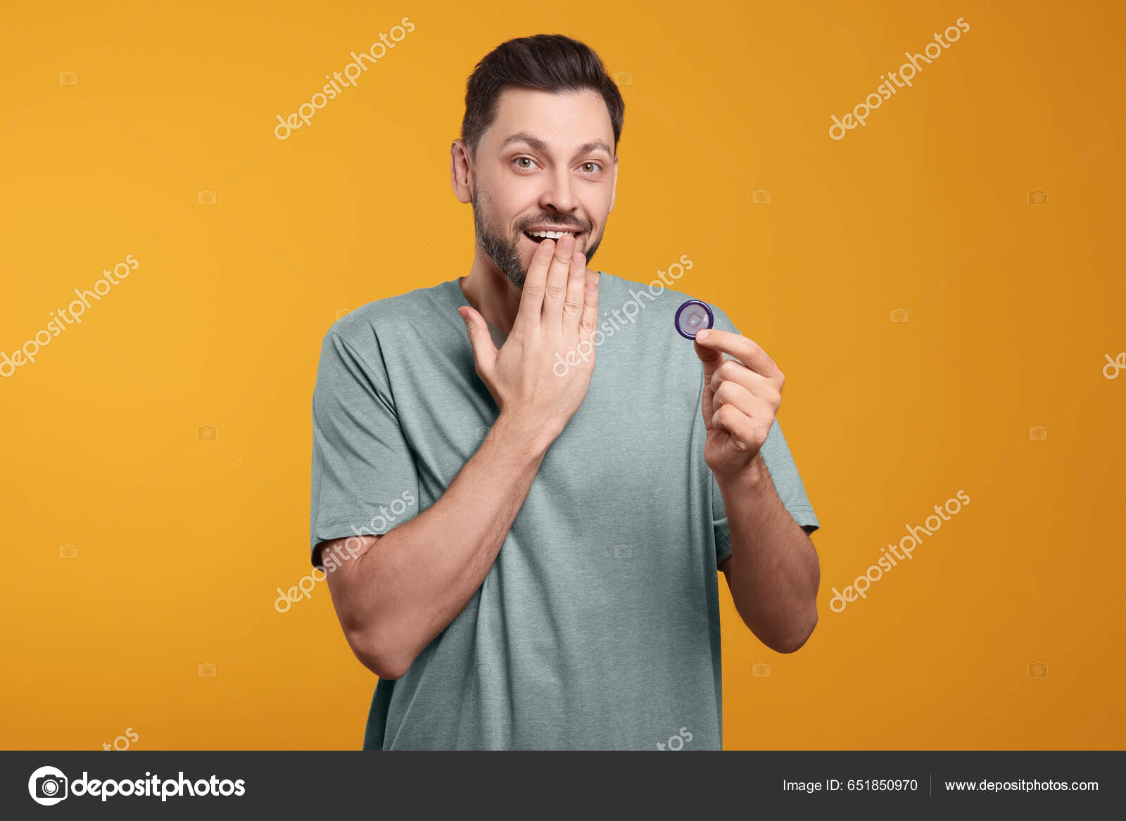 Confused Man Holding Condom Orange Background Stock Photo By.