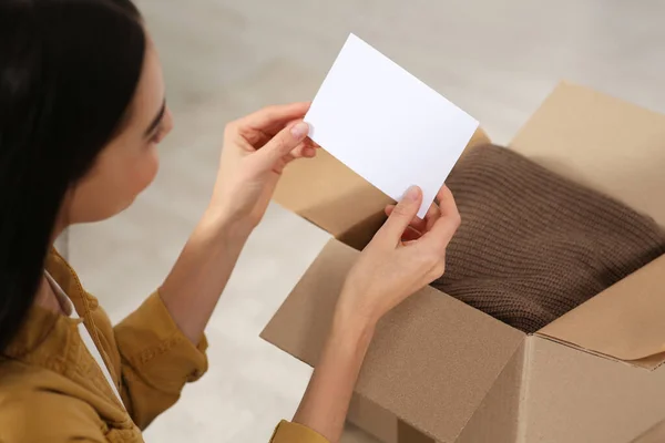 Vrouw Met Wenskaart Buurt Van Pakket Met Kerstcadeau Binnen Close — Stockfoto