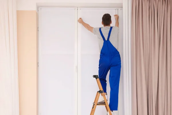Arbeiter Uniform Montiert Rollladen Auf Leiter Innenraum Rückansicht — Stockfoto