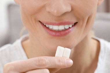 Kadın, arka planda sakız parçaları çiğniyor. Yakın plan.