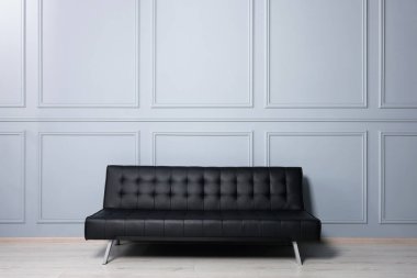 Beyaz duvarın yanındaki şık deri kanepe. İç tasarım