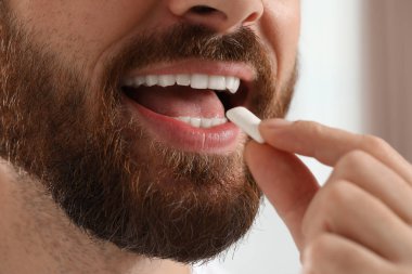 Bulanık arka planda sakızı olan adam, yakın plan.
