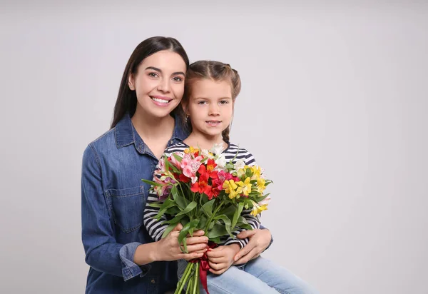 Mujer Feliz Con Linda Hija Ramo Hermosas Flores Sobre Fondo — Foto de Stock