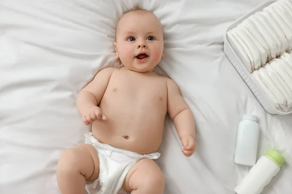 Söt Baby Blöjor Och Kosmetiska Produkter Vit Säng Ovanifrån — Stockfoto