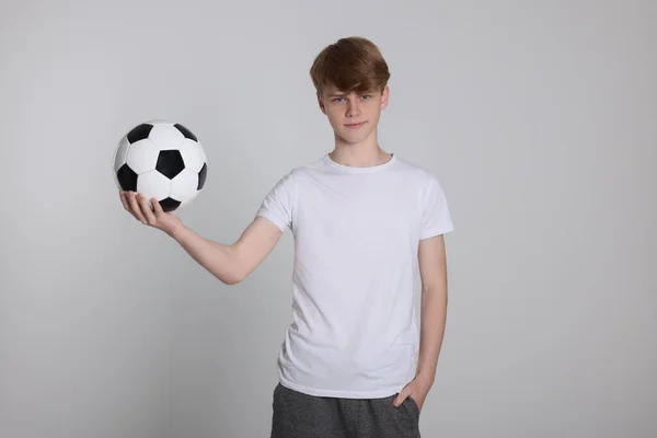 Açık Gri Arka Planda Futbol Topu Olan Genç Bir Çocuk — Stok fotoğraf