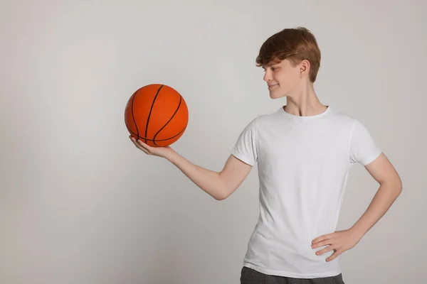 Açık Gri Arka Planda Basketbol Topu Olan Genç Bir Çocuk — Stok fotoğraf