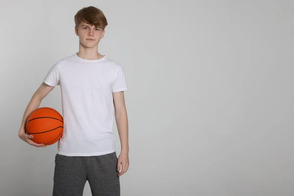 Teenage Chlapec Basketbalovým Míčem Světle Šedém Pozadí Mezera Pro Text — Stock fotografie