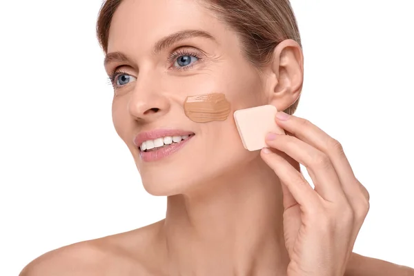 Kvinna Applicera Foundation Ansiktet Med Makeup Svamp Mot Vit Bakgrund — Stockfoto