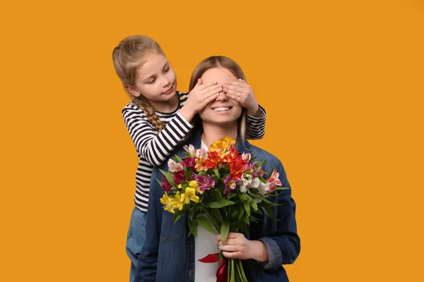 Petite Fille Félicitant Mère Avec Des Fleurs Sur Fond Orange — Photo