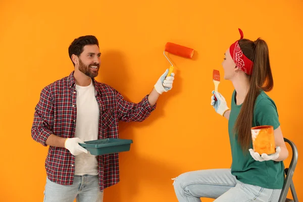 Man Painting Orange Wall Happy Woman Holding Can Dye Brush — Foto de Stock