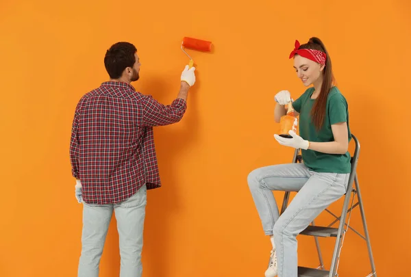 Man Painting Orange Wall Happy Woman Holding Can Dye Brush — Φωτογραφία Αρχείου
