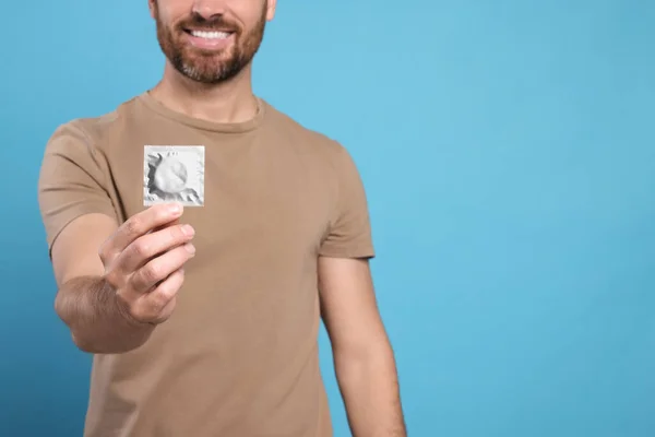 Man Holding Condom Light Blue Background Closeup Space Text Safe — Stock Photo, Image