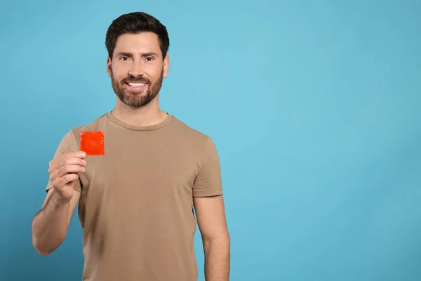 Hombre Feliz Sosteniendo Condón Sobre Fondo Azul Claro Espacio Para — Foto de Stock