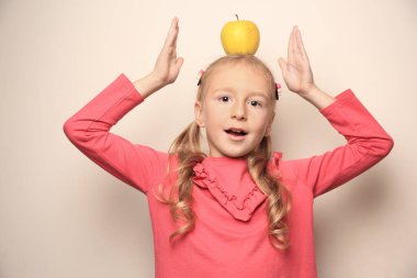 Hafif arka planda elması olan tatlı küçük bir kız.