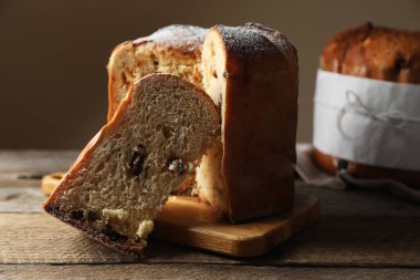 Lezzetli kesim Panettone pastası, ahşap masada kuru üzümlü, yakın plan. Geleneksel İtalyan pastası