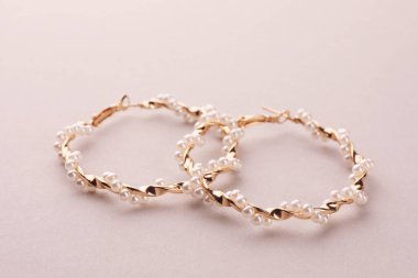 Bej arkaplanlı inci küpeler.