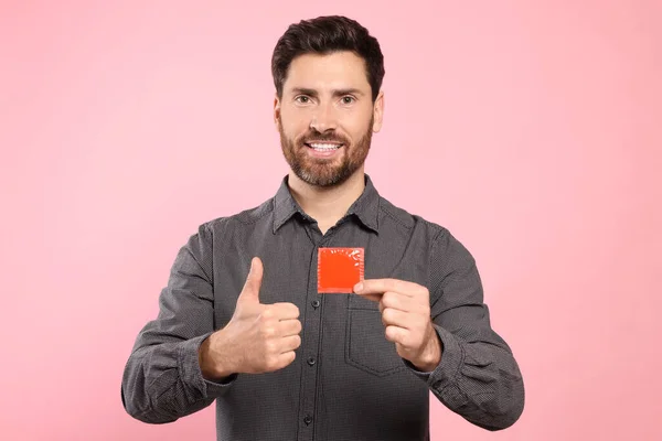 Щасливий Чоловік Презервативом Показує Великий Палець Рожевому Тлі Безпечний Секс — стокове фото