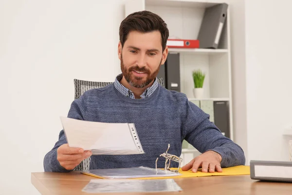 ビジネスマンはオフィスの木製のテーブルで文書を読む — ストック写真
