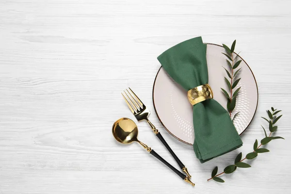 stock image Stylish setting with cutlery and eucalyptus leaves on white wooden table, flat lay. Space for text