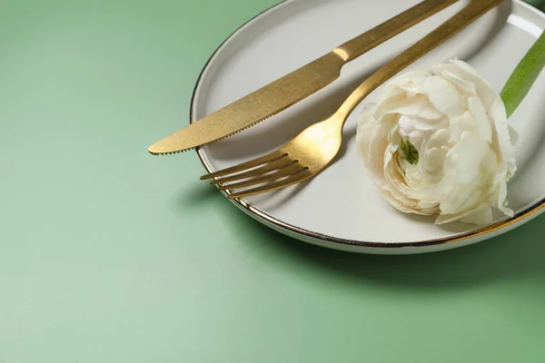 stock image Stylish table setting with cutlery and flower on olive background, closeup. Space for text