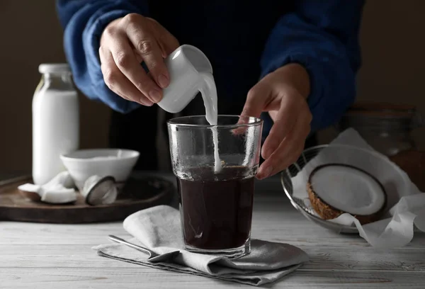 Donna Che Versa Latte Cocco Nel Bicchiere Caffè Tavolo Legno — Foto Stock