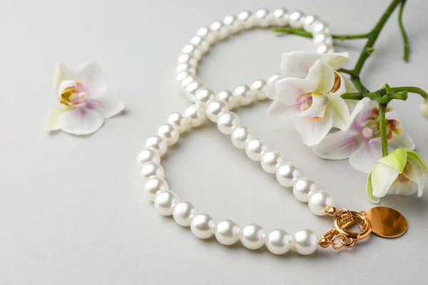 Elegáns Gyöngy Nyaklánc Orchidea Virágok Fehér Alapon Közelkép — Stock Fotó