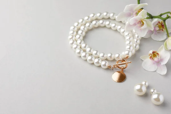 Elegante Perlenkette Ohrringe Und Orchideenblumen Auf Weißem Hintergrund Raum Für — Stockfoto
