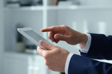 Kapalı alanda yeni tablet kullanan adamın yakın görüntüsü