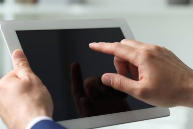 Kapalı alanda yeni tablet kullanan adamın yakın görüntüsü