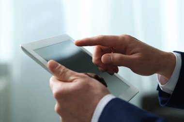 Kapalı alanda yeni tablet kullanan adamın yakın görüntüsü