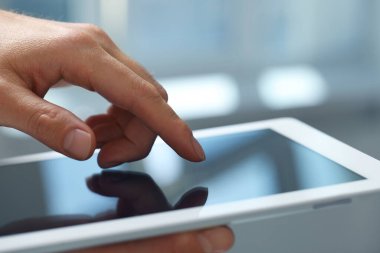 Kapalı alanda yeni tablet kullanan adamın yakın görüntüsü