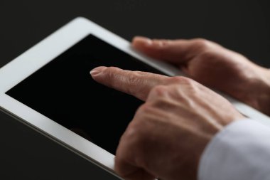 Kapalı alanda yeni tablet kullanan adamın yakın görüntüsü